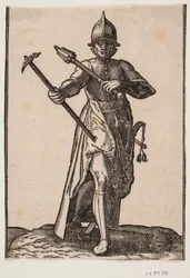 Soldado de capacete em pé, vista frontal; em r. mão um martelo de guerra, em v. mão uma clava de guerra, perna e pé de trás distorcidos em relação à frente; ao lado de uma espada