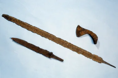 Arte merovíngia: fíbulas e uma francisca (machado) de ferro provenientes da Normandia. 475-525 d.C. Museu de Arqueologia Nacional, Saint-Germain-en-Laye