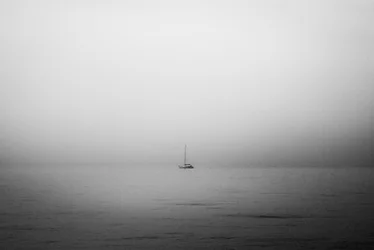 Barco à vela solitário no nevoeiro
