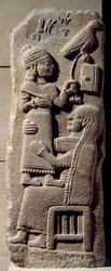 Baixo relevo basáltico retratando o escriba Tarhunpiyas nos joelhos da mãe, segurando a escritura e um falcão de caça. Fim do século VIII a.C. De Marash, Anatólia. Era Neo-hittita (1050-800 a.C.) Dim. 0,75x0,28 m. Paris, Museu do Louvre.