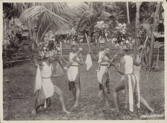 Meninos indianos em trajes dançando com kris na mão