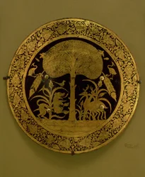 Placa com uma borda de flores estilizadas em torno de uma cena de animais exóticos sob uma árvore espalhando (bronze dourado)