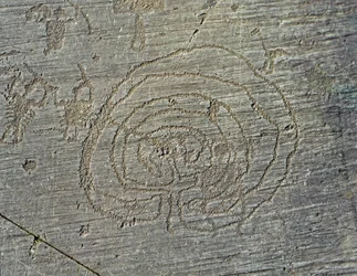 Pré-história, civilização dos Camunos, arte rupestre: uma rocha gravada com a representação de armas de guerreiros, escudos e espadas, e de um labirinto. Período entre o Neolítico e a Idade do Bronze. Rocha n.º 35, Capo di Ponte, Parco nazionale delle
