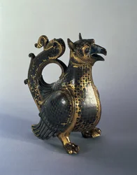 Jarro de água em forma de grifo, início do século XII (bronze dourado com niello)