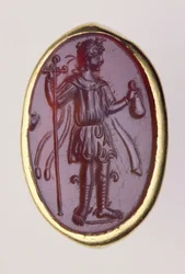 Intaglio inserido num anel de ouro que representa uma figura masculina jovem, século II a.C. (ouro e barba)
