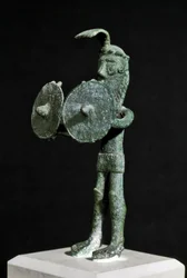 Cultura nurágica (nuragues), sarda: estatueta que representa uma criatura demoníaca armada com um escudo duplo de bronze. Séculos VIII-VII a.C. Cagliari, Museo Nazionale Archeologico, Sardenha, Itália