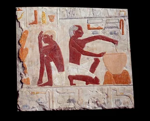 Arte Egípcia Antiga: cozer pão. Um homem faz pasta de bolo, outro monitora o cozimento dos moldes de pão. Pedra calcária (2500-2350 a.C.) 5ª dinastia. Paris, Musee Du Louvre