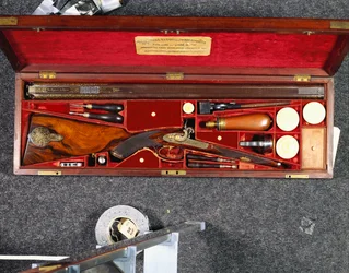 Uma espingarda de percussão D.B. de 16 canos, decorada a ouro, feita para o Nizam de Hyderabad, num estojo de mogno montado em latão, forrado a seda carmesim, c.1855 (seda, mogno, aço, cobre)