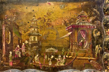 Uma mesa de chá, detalhe do topo onde há uma paisagem com cenas de vida em imitação de lacas chinesas