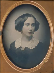 Jovem mulher vestindo colar e broche de renda, década de 1850.