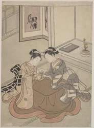 Duas mulheres jovens sentadas por um berço de gato jogando Kotatsu