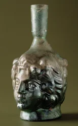 Vidro "Rohnsches", frasco de perfume em forma de cabeça, sírio do século II-3º (vidro)