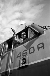 Maquinista da Great Northern Railroad acena da cabina de uma locomotiva EMD E7