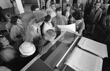 Visitantes da Feira Mundial de Seattle de 1962 examinam o ecrã do computador mainframe UNIVAC.