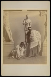 [Dois estudantes do sexo masculino em traje grego diante de um molde de gesso de Afrodite na sala de gesso da Academia da Pensilvânia]