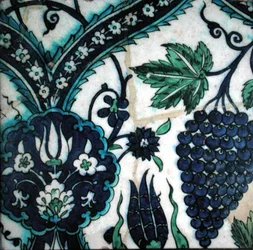 Azulejo Isnik com flores e um cacho de uvas (terracota com vegetação rasteira colorida)