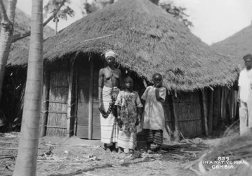 Uma família na frente de sua casa, Gâmbia, século 20