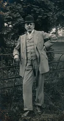 Um cavalheiro vestindo um terno e chapéu-coco c1910