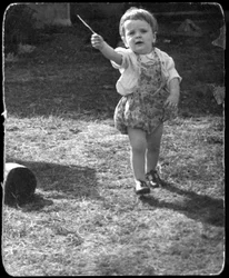 Andrew Nurnberg, filho do fotógrafo Walter com pau no jardim, C1954