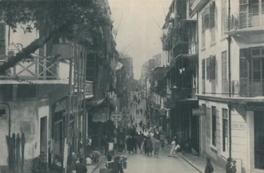 Edifícios com varandas de uma rodovia comercial movimentada, leste e oeste, c1935