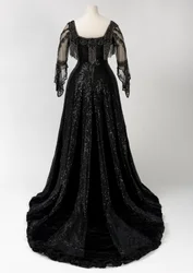 Vestido de noite preto comprido usado pela rainha Alexandra, com decoração de missangas e lantejoulas e incorporando a característica fita de seda preta com o nome da rainha Alexandra em letras douradas, feito por Barolet of Knightsbridge, Londres