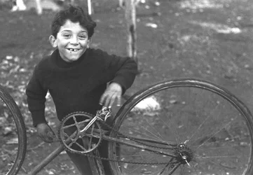 Criança a arranjar uma bicicleta, Borghetto Nomentano, Roma, Itália