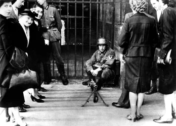 Civis em frente a um posto de guarda alemão com uma metralhadora, Paris, junho de 1940