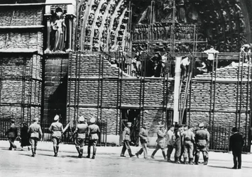 Limpeza da proteção de sacos de areia da fachada de Notre Dame, Paris ocupada pela Alemanha, 1940