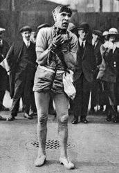 Um escapologista entretém os espectadores na fila para a plateia, Londres, 1926-1927