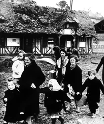 Famílias deixando sua vila bombardeadas durante o desembarque na Normandia, França, 1944
