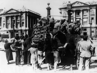 Vendedores de rua franceses que oferecem lembranças a um caminhão cheio de soldados alemães, Paris, 27 de julho de 1940