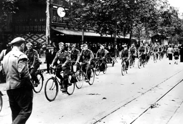 Soldado alemão andando de bicicleta pelas ruas de Paris, junho de 1940