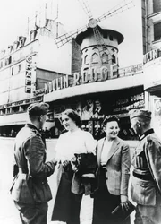 Soldados alemães conversando com francesas do lado de fora do Moulin Rouge, Paris ocupada, junho de 1940