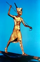 Figura de ouro do rei Tutankhamon em pé em um barco de junco e lanças de peixe, século 14 aC