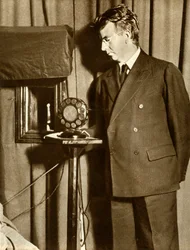 John Logie Baird assistindo a primeira peça a ser televisionada, 14 de julho de 1930, 1935.