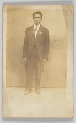 Postal fotográfico de um homem de terno, 1904-1918.