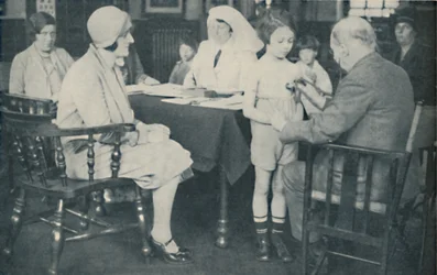 O médico ouvindo uma batida do coração da criança, c1935