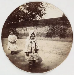"Two small children walking alongside a wall", vers les annees 1890