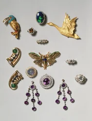 Seleção de joias: brincos pendentes de ametista e diamantes; broche de safira-estrela em cabochão e diamantes; anel de opala negra; broche ou pendente de ametista e diamantes; broche de mola em ouro com cisne voador; Tiff