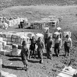 Uma lixeira de ração e homens carregando mais suprimentos para ela, março de 1943 (slide lanterna)