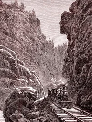 Um comboio a atravessar as montanhas do Colorado. E.U.A. em 1886 (gravura)
