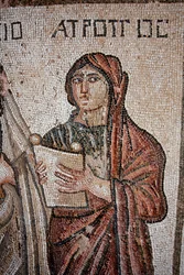 Atropos - Um dos três destinos representados com um pergaminho aberto sobre o qual foi inscrita a vida de Aquiles - Detalhe do painel representando o primeiro banho de Aquiles - Mosaicos Paphos, Vila de Theseus, Século V d.C. - Chipre - Representação de At