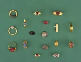Coleção de jóias romanas, etruscas e helenísticas, incluindo um anel de escaravelho fenício, um camafeu, porta-amuletos e uma ágata intaglio, desde o século VI a.C. até o IV d.C.