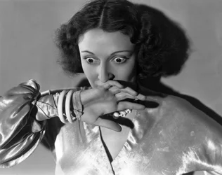 Hollywood, Califórnia: c.1932 Grande plano de uma jovem mulher cobrindo a boca com medo. (foto a p/b)