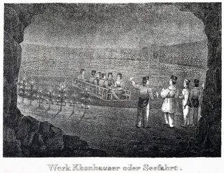 Mina de sal: um grupo de visitantes atravessando o lago salino subterrâneo da mina em um barco, em Durrnburg, Áustria