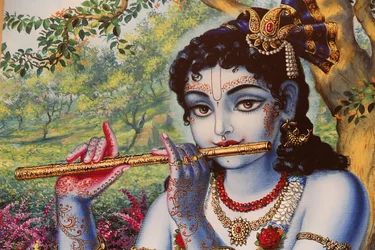Pintando representando o deus hindu Krishna tocando uma flauta ao ar livre. Índia
