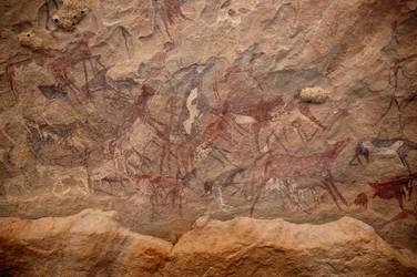 Arte rupestre, Pré-história: Pintura rupestre de um grupo de gado e personagens policromáticas num abrigo ornamentado, no maciço de Uweinat, Sudão. Período de 8000 a 3000 anos antes de Cristo. Fotografia