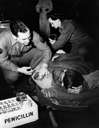 Segunda Guerra Mundial (1939-1945) - Segunda Guerra Mundial (II Guerra Mundial ou 2ª Guerra Mundial): Luxemburgo, Fevereiro de 1945: Num hospital de evacuação do exército americano, um médico (enfermeiro) administra penicilina a um soldado ferido para evit
