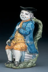 Jarro Toby com rosto e mãos pálidos de manganês, segurando e vazio o jarro globular de cor lustrosa no casaco azul lavado e calções e colete verde, c.1800