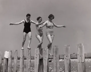Duas mulheres e um homem caminhando ao longo de um groyne, c 1930s